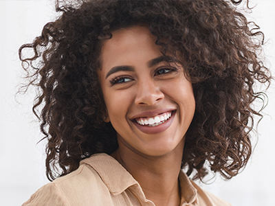 Smiling woman with curly hair and a joyful expression.